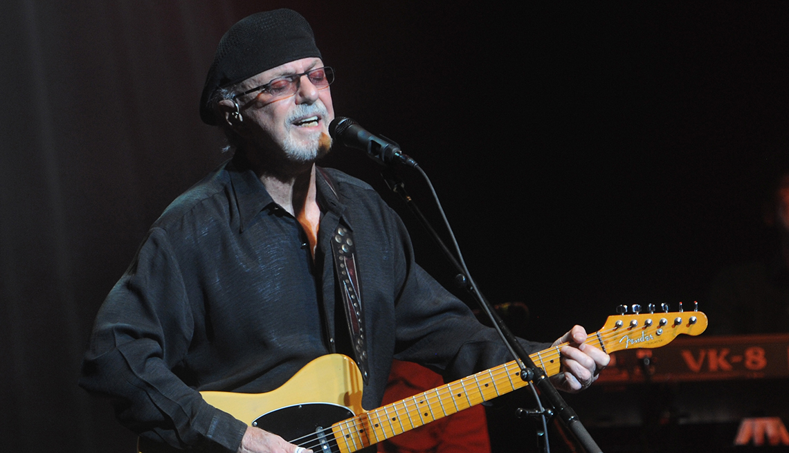 Dion Dimucci playing a guitar as he performs at St. George Theatre in New York City