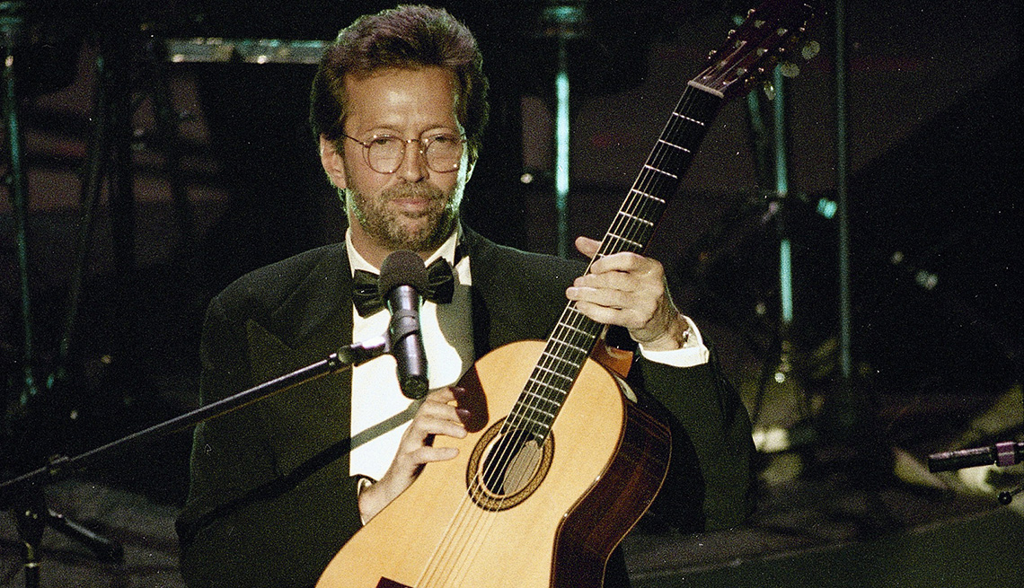 Eric Clapton holds his guitar onstage during his performance of Tears in Heaven at the 35th annual Grammy Awards