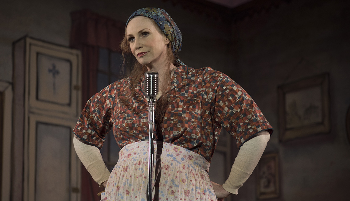 Jane Lynch standing behind a microphone in The Marvelous Mrs Maisel