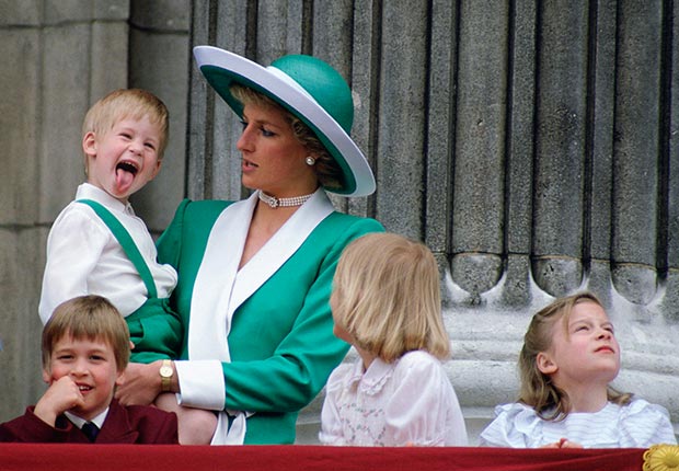 Prince Harry stuck out his tongue while being held by his mother, Princess Diana, on the balcony of Buckingham Palace in June 1988. (Tim Graham/Getty Images)