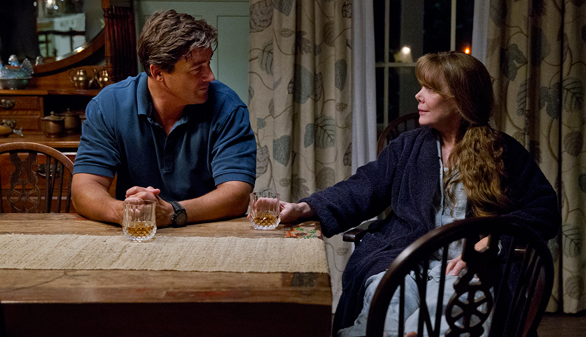 Kyle Chandler and Sissy Spacek sitting at a kitchen table sharing a drink in 'Bloodline'