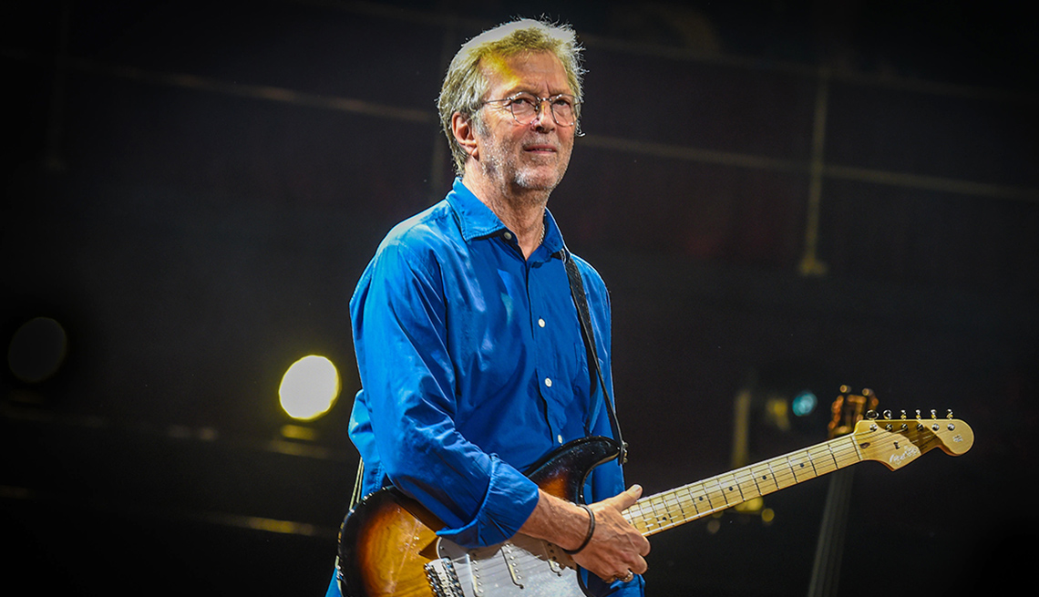 Eric Clapton holding guitar on stage