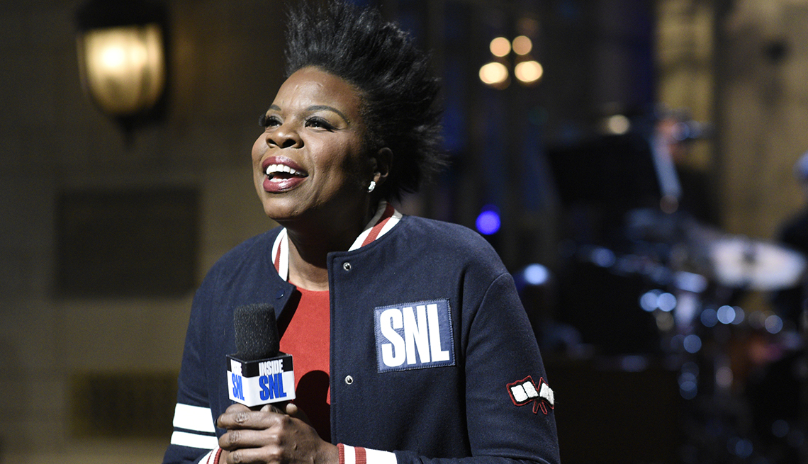Leslie Jones wearing an SNL jacket and holding a microphone during an opening monologue on "Saturday Night Live"