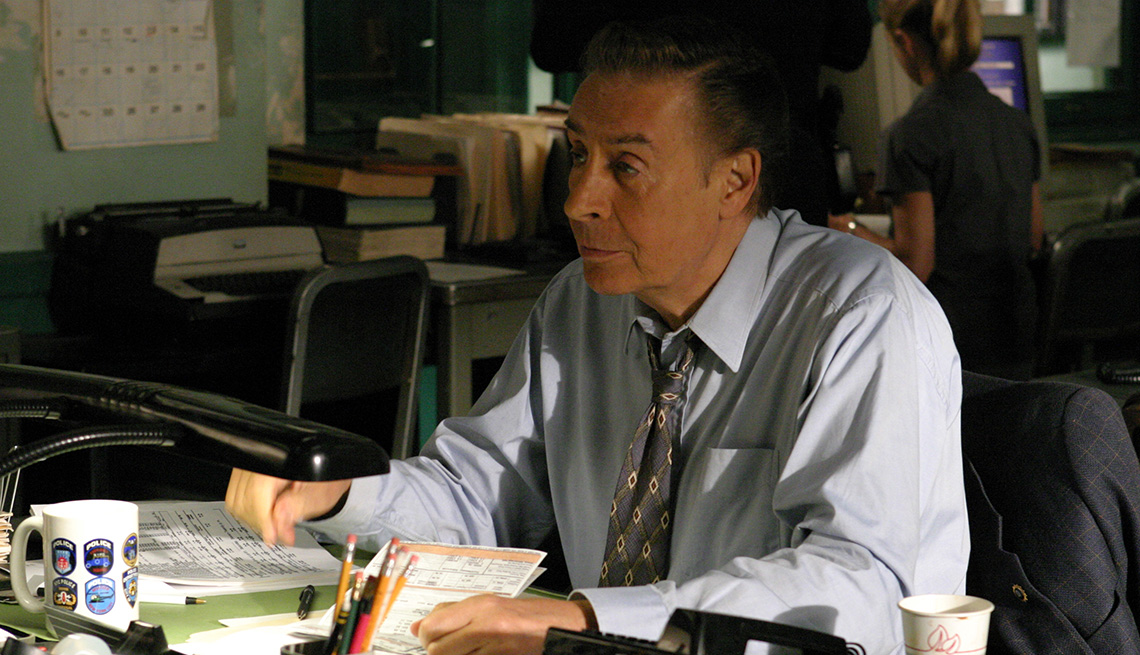 Jerry Orbach sits at his desk in the Law and Order episode C O D