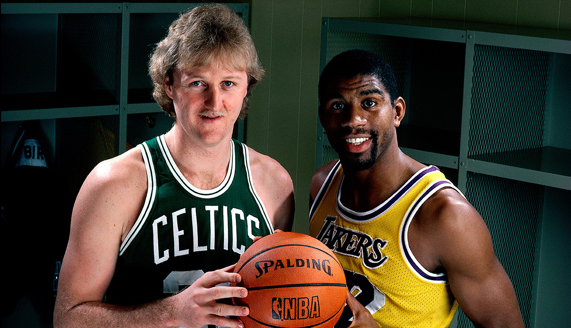 Boston Celtics star Larry Bird and Los Angeles Lakers star Magic Johnson pose for a portrait together while they both hold a Spalding NBA basketball