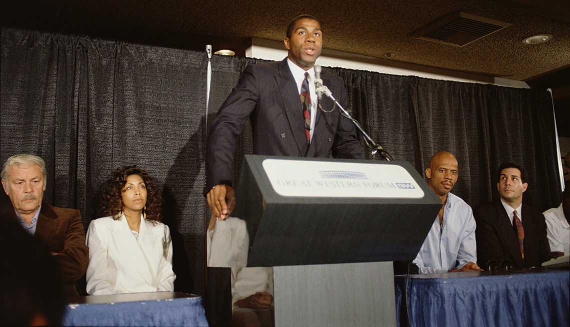 Magic Johnson speaks at the podium at a press conference announcing  his retirement from basketball after being diagnosed HIV positive