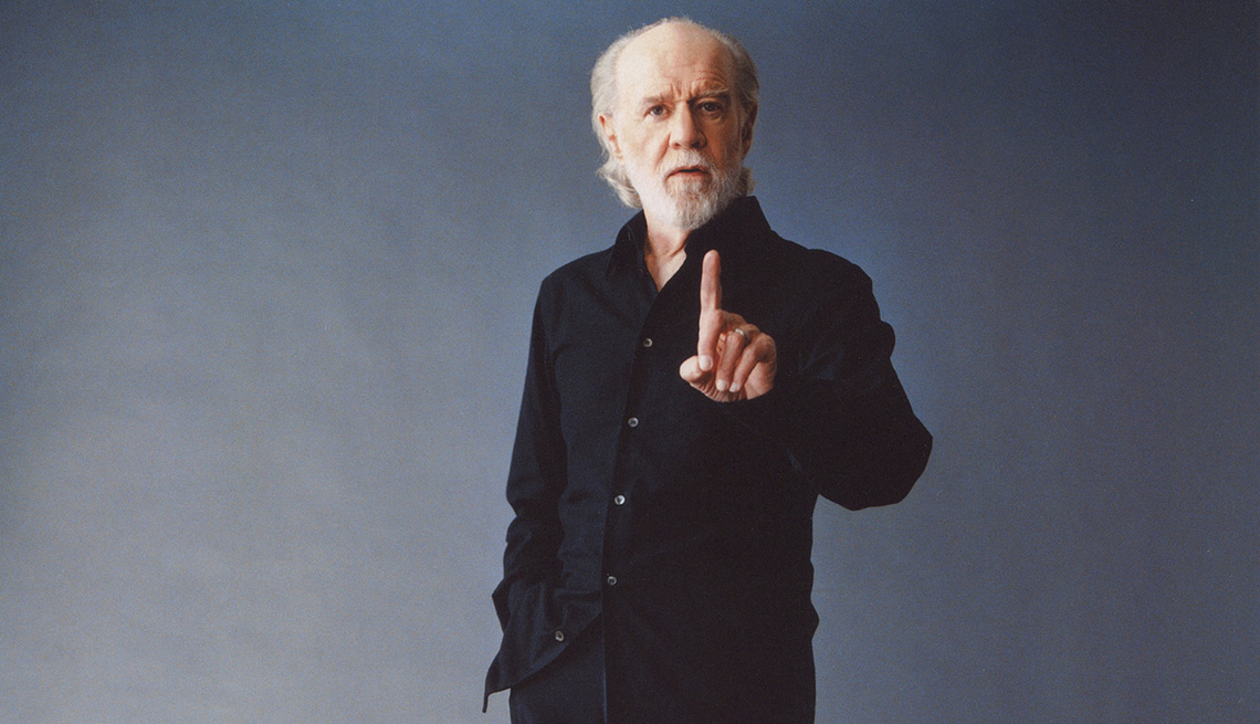 Comedian George Carlin holding up his index finger