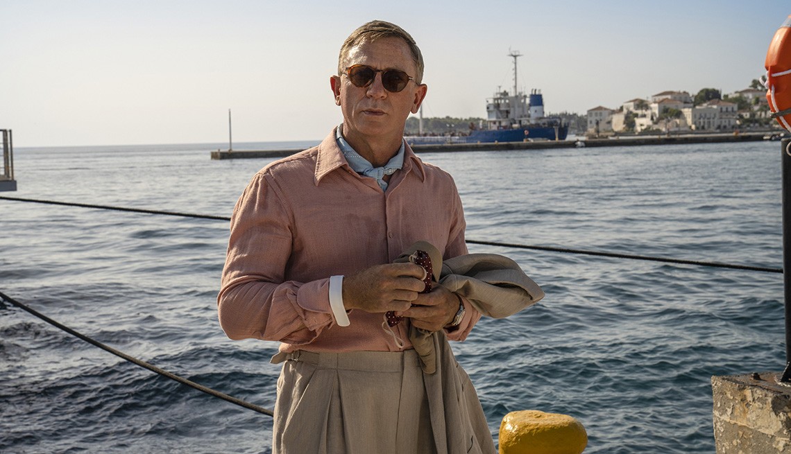 Daniel Craig standing outside near a body of water in Glass Onion: A Knives Out Mystery