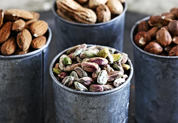 Selection of nuts on table in pots, calorie dense foods