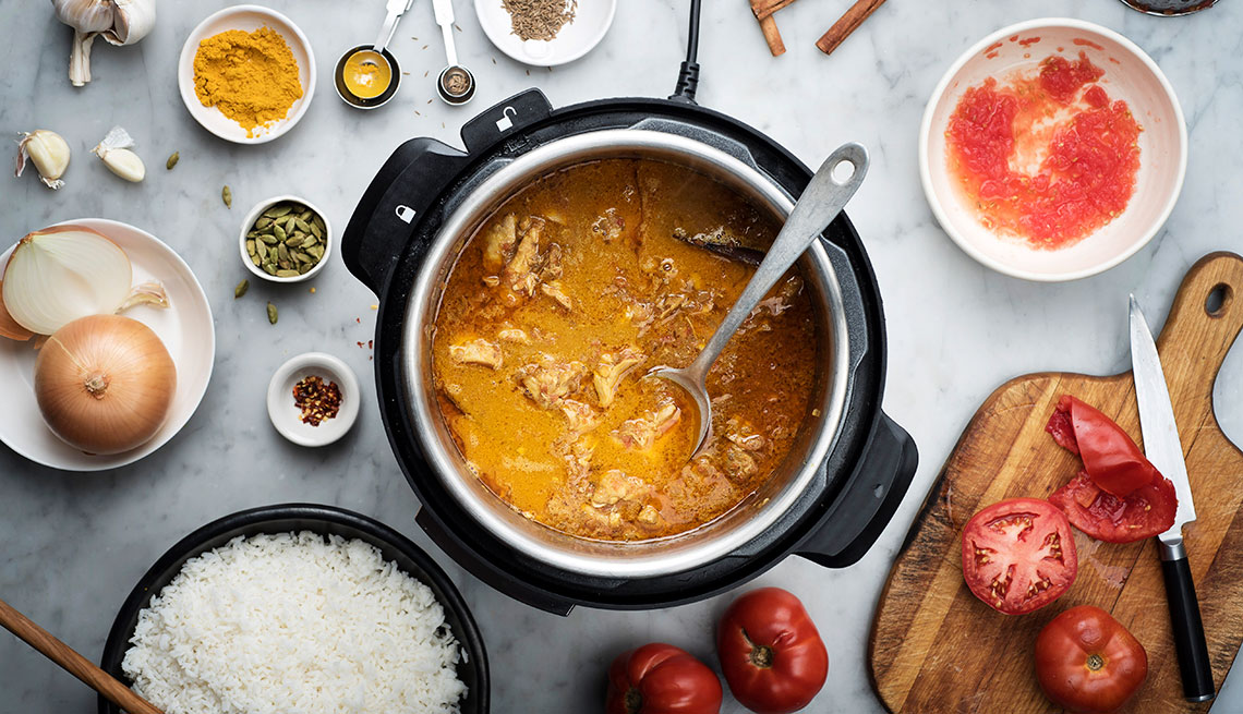 Coconut curry chicken is prepared in an Instant Pot cooker.