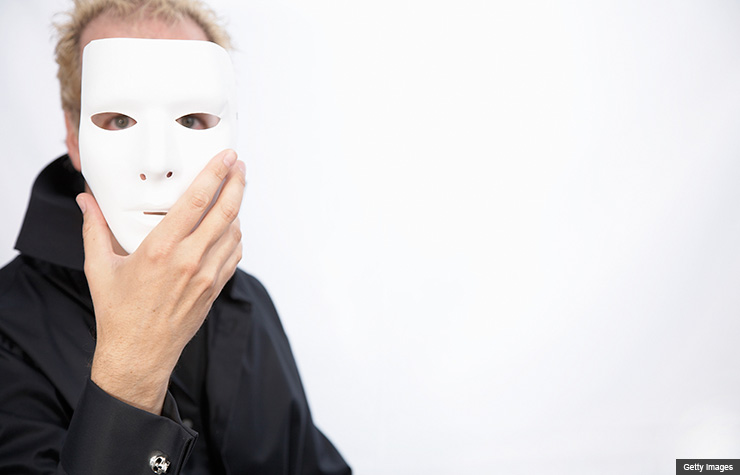 Mature man holding mask in front of face, Brain changes in older people may make them more prone to scams