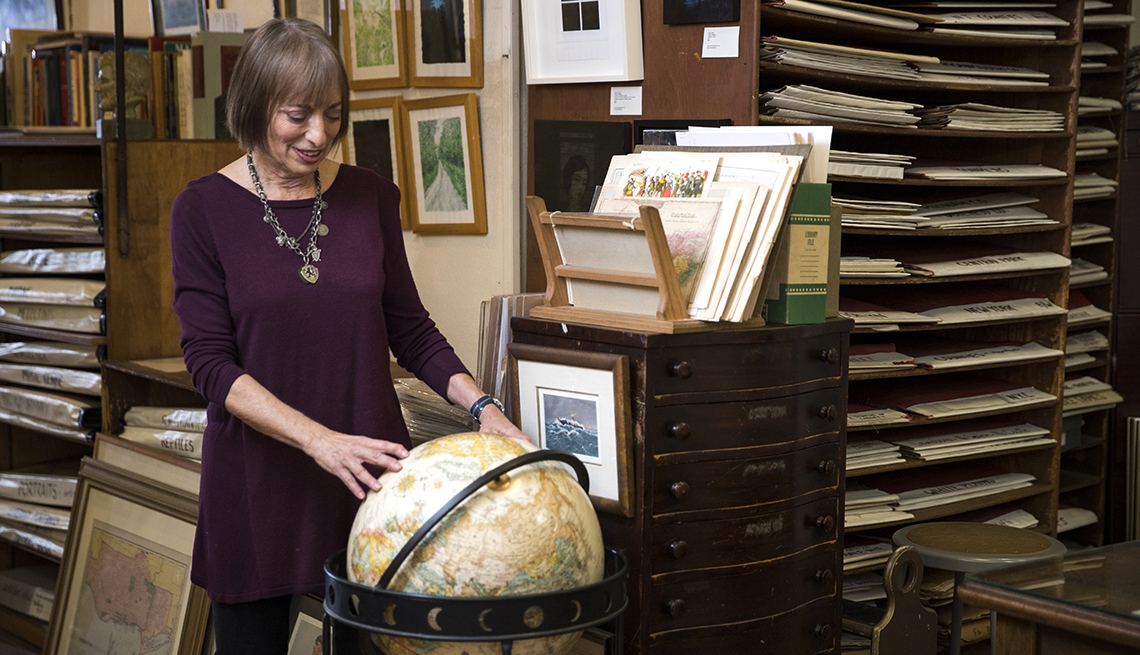 Novelist Catherine Hiller looking at a globe of the world