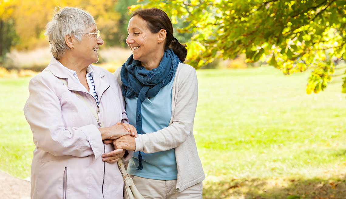 senior woman and carer walking in the park