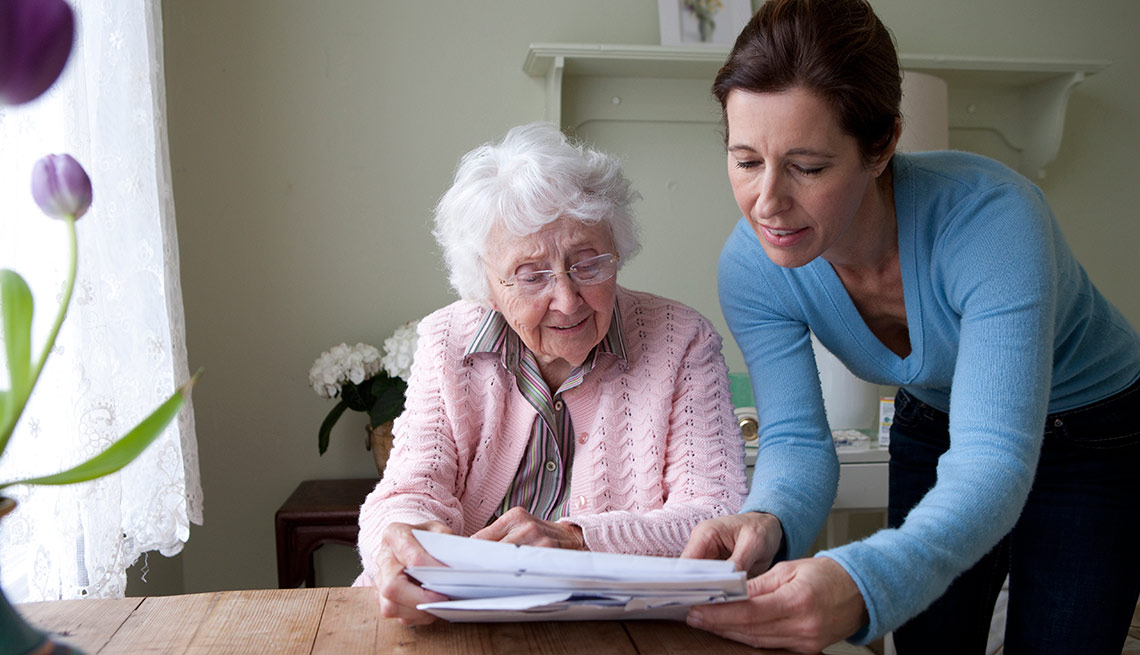 Cómo manejar tu tiempo efectivamente si cuidas de alguien - Mujer le enseña documentos a una abuela