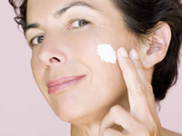 Woman applying cream to cheek. Which over the counter skin care products work best?