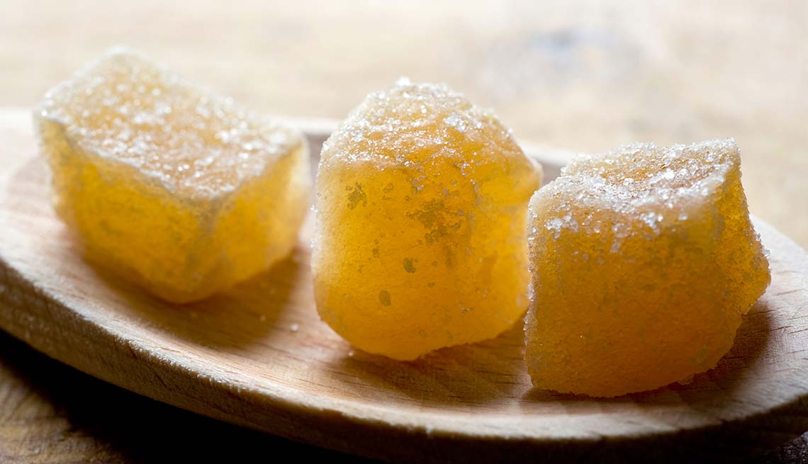 three pieces of crystallized ginger on a wooden spoon