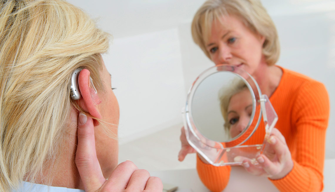 Mujer probandose un audífono - Mitos sobre la pérdida auditiva