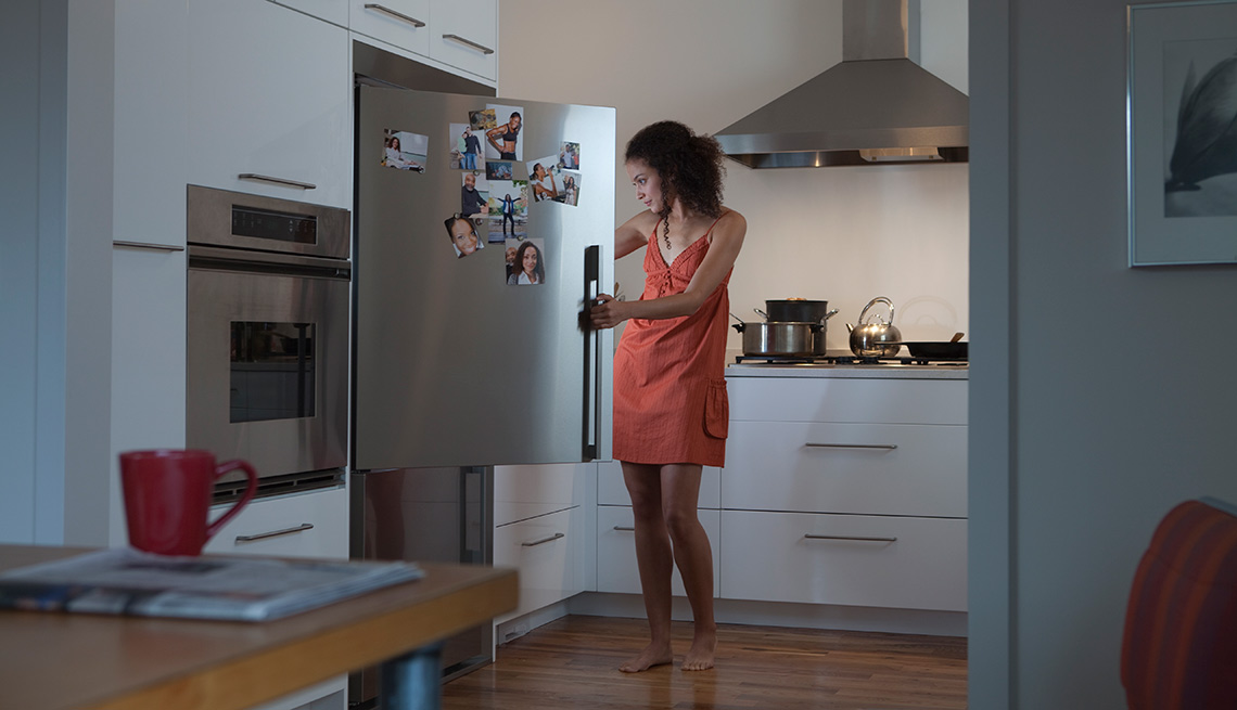 Mujer buscando en un refrigerador