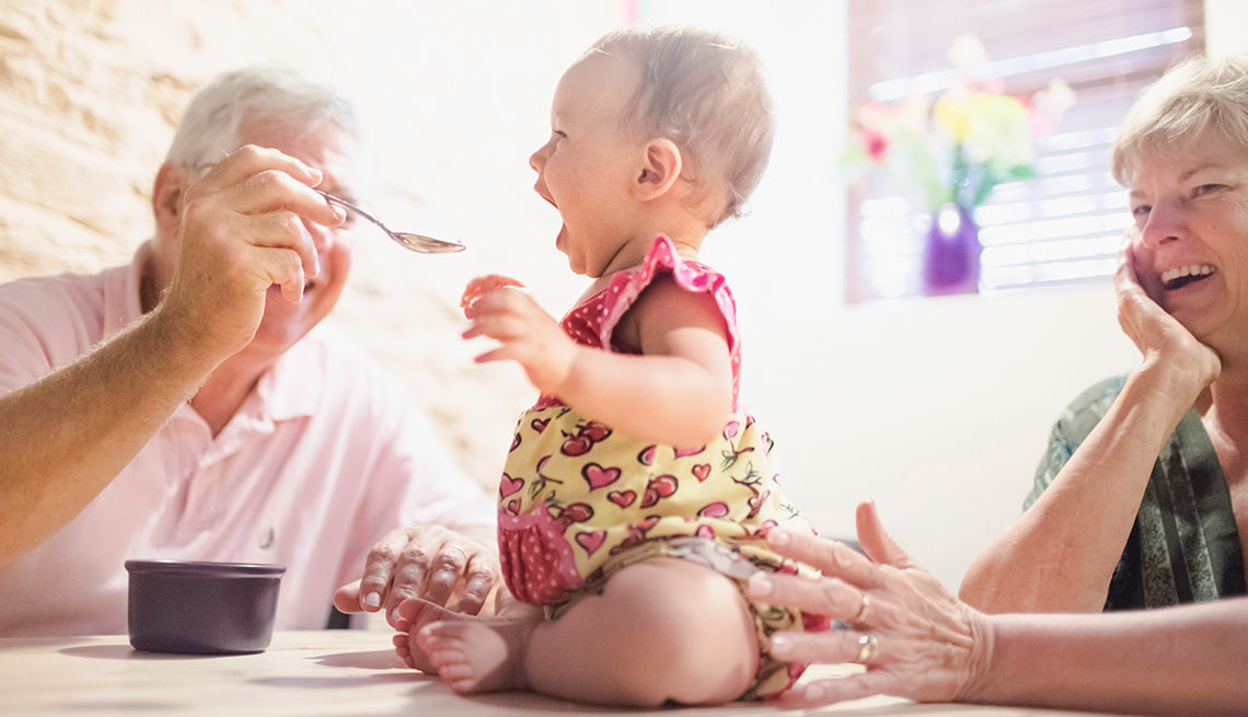 Abuelos alimentando a su nieta bebé