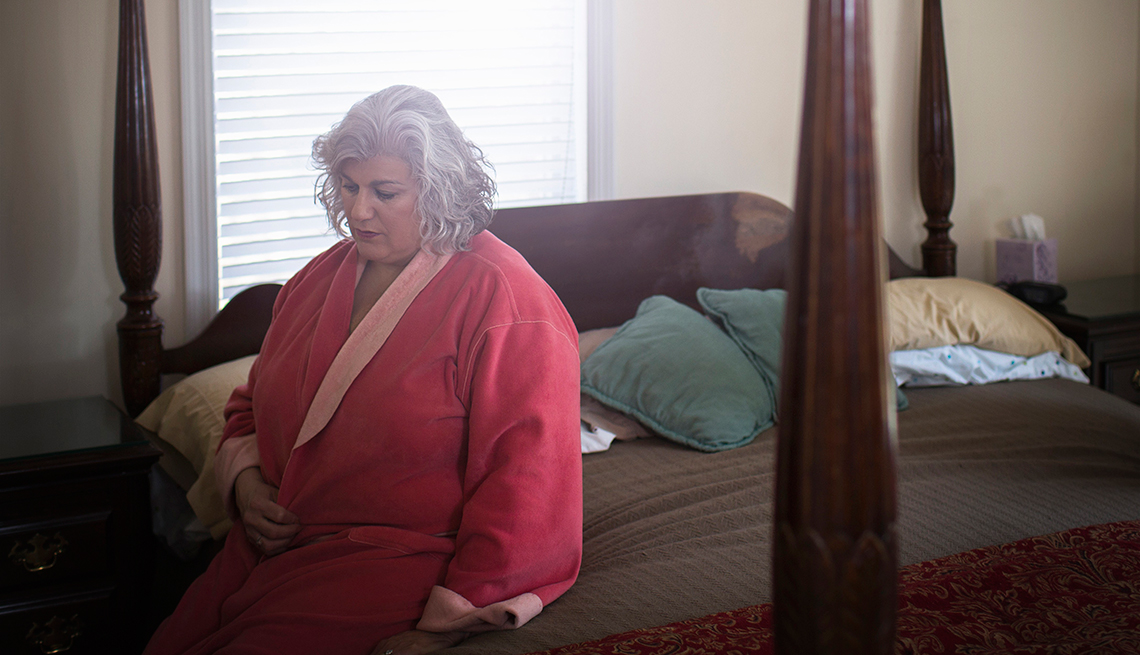 Mujer adulta y obesa sentada sobre una cama