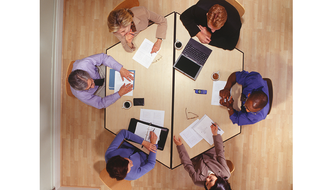 Overhead view of business meeting at a round table, Workplace hearing loss coping stategies