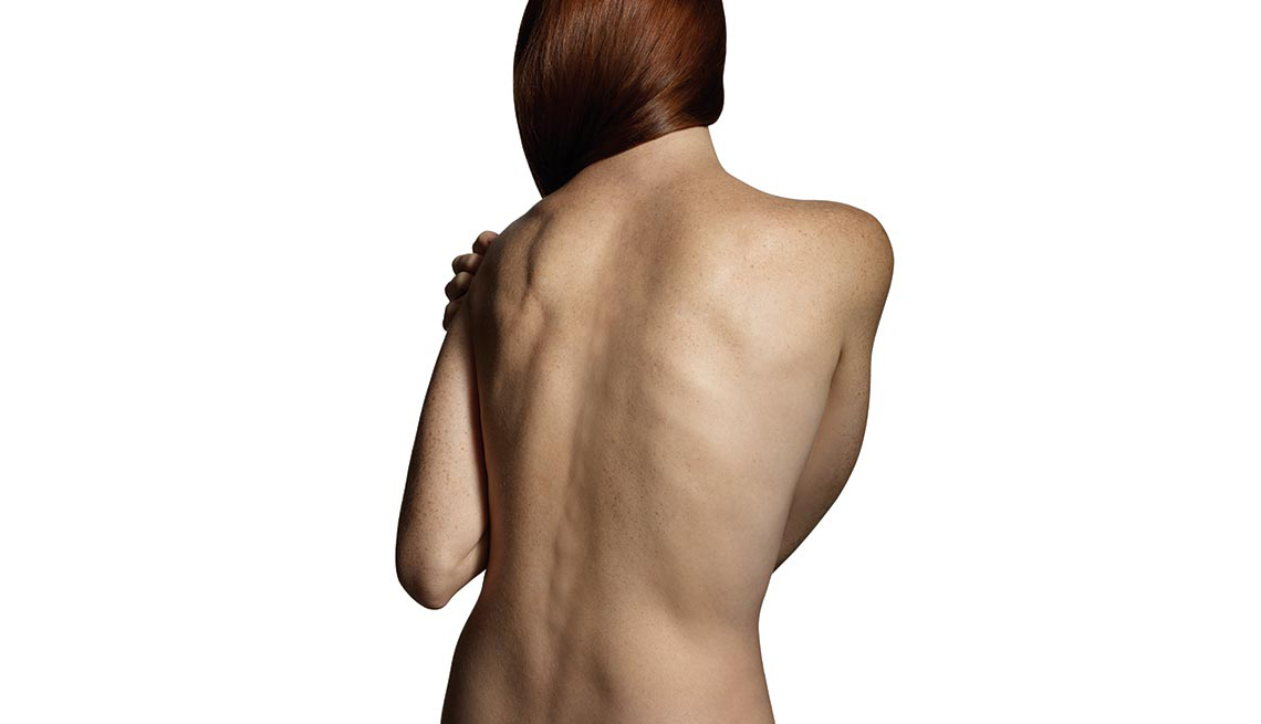 Mujer de espaldas, desnuda y agarrándose un hombro - Formas de manejar el dolor