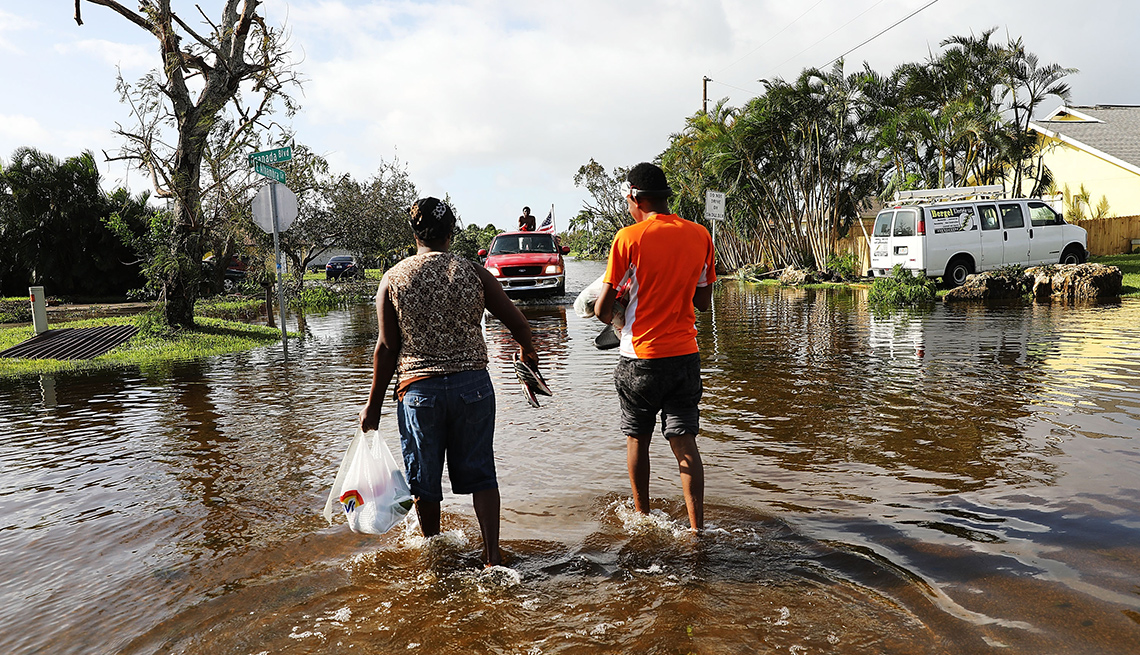 Personas caminando por una zona inundada luego de un desastre natural