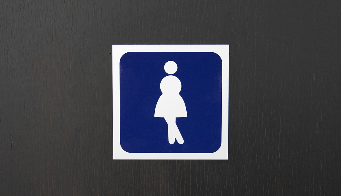 Rótulo de baño con figura de mujer cruzando las piernas