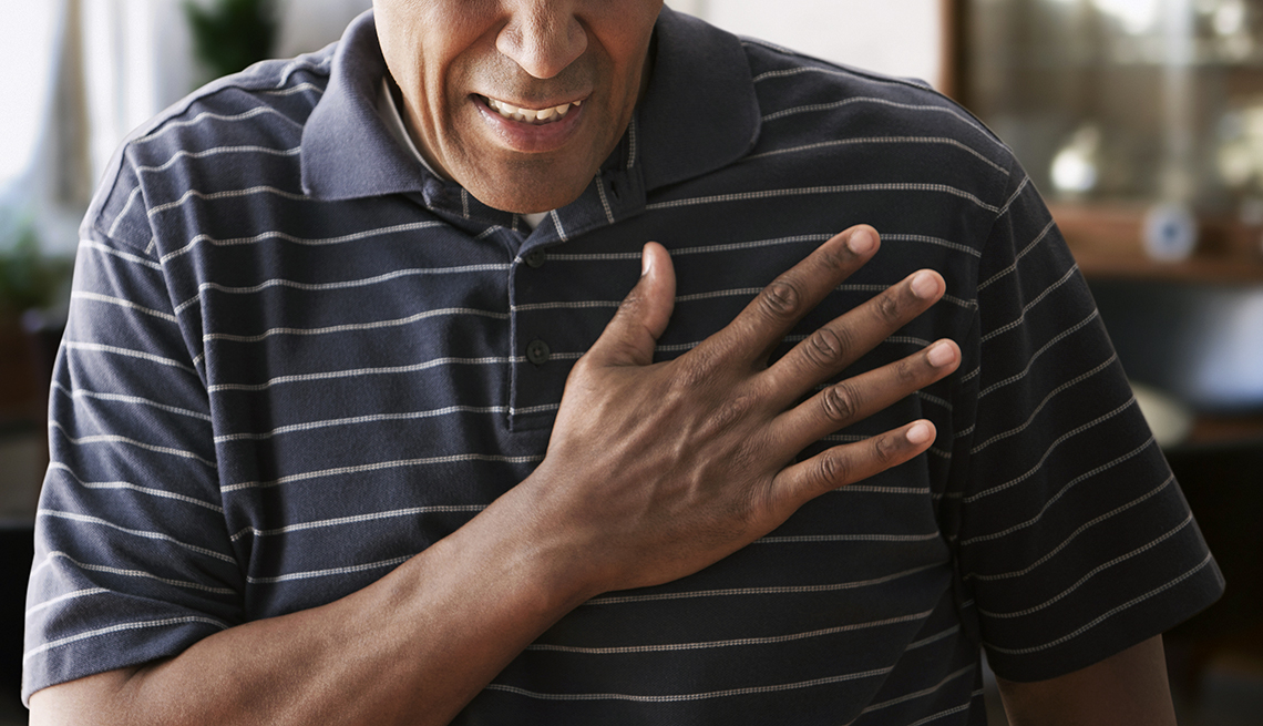 Man holds hand to chest, pained expression