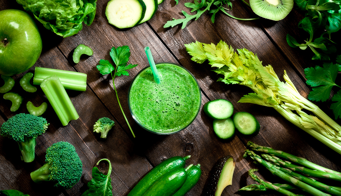 Green veggies surround a green smoothie