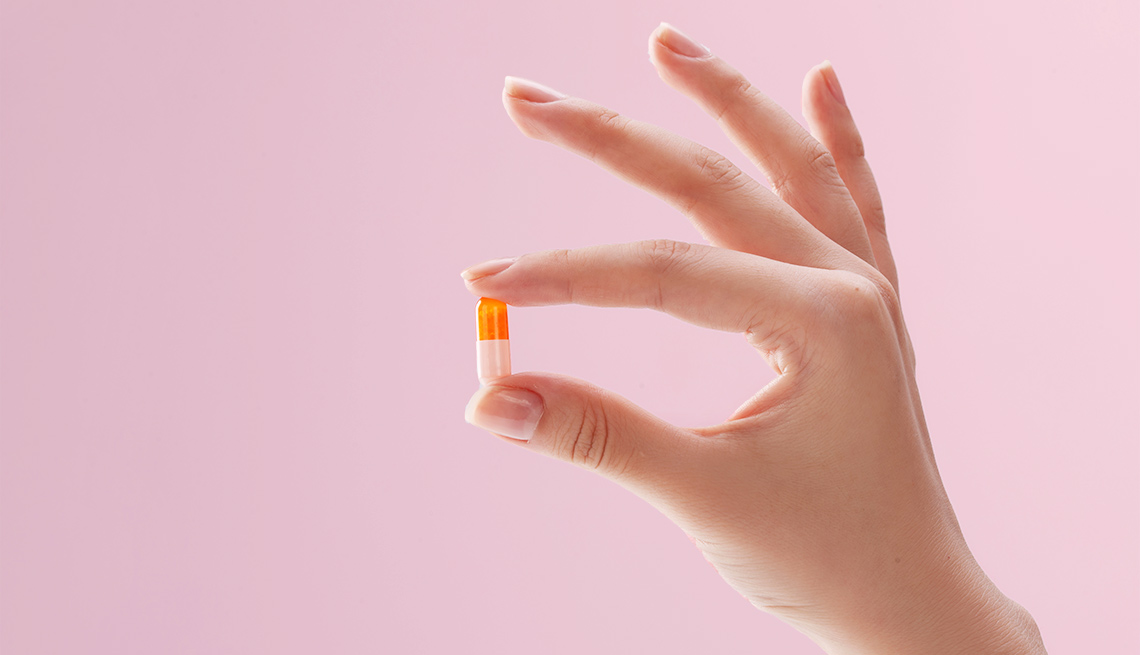 Woman's hand holding pill