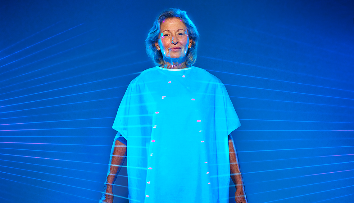 Mature woman wearing hospital gown with lines pointing to various parts of her body for medical testing.