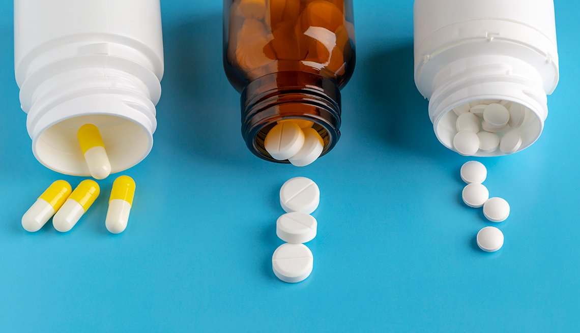 Various pills bottles and heap of drugs on blue backround