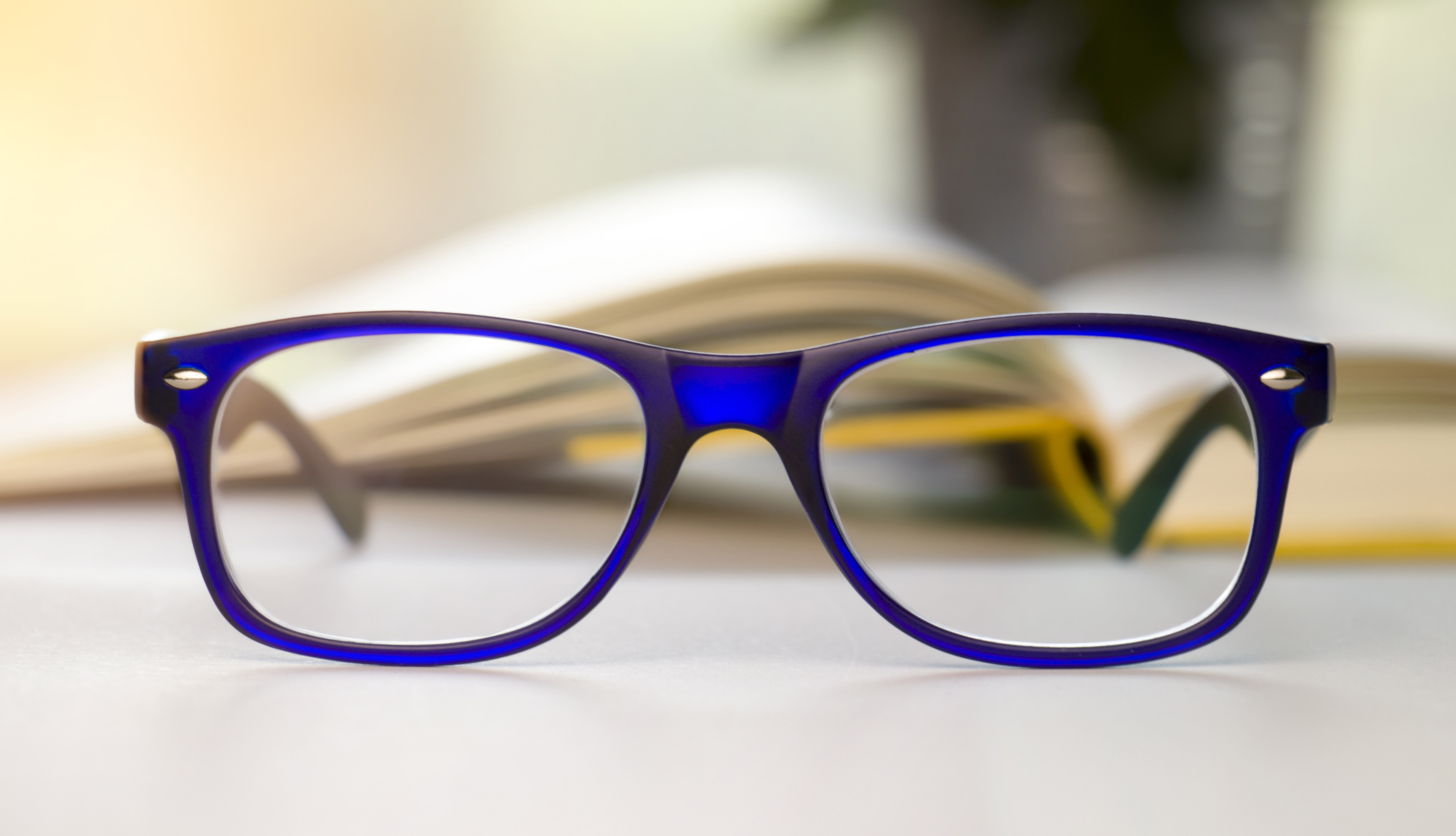 Stylish blue glasses on a blur background.