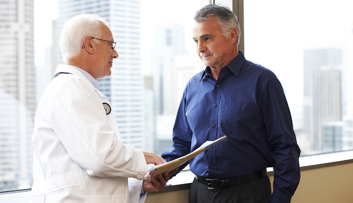 Doctor discusses file with senior patient