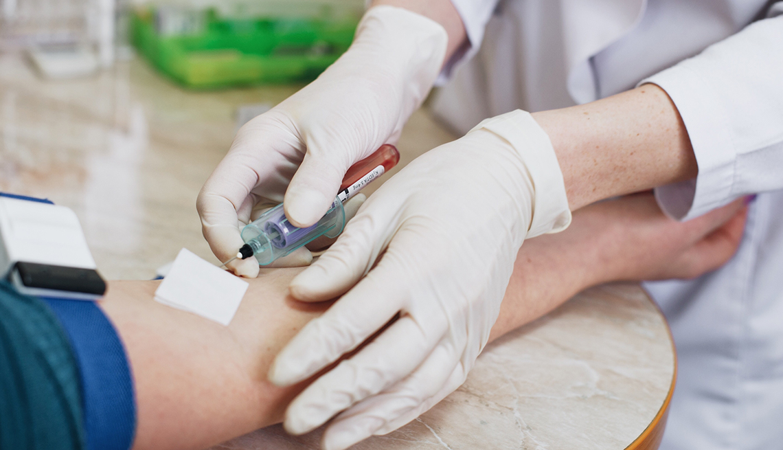 A doctor or nurse drawing blood from a patient for testing