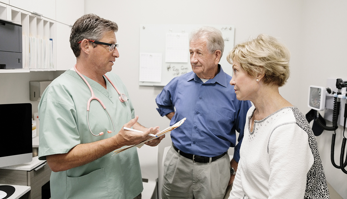 A doctor is speaking to a couple in an examination room