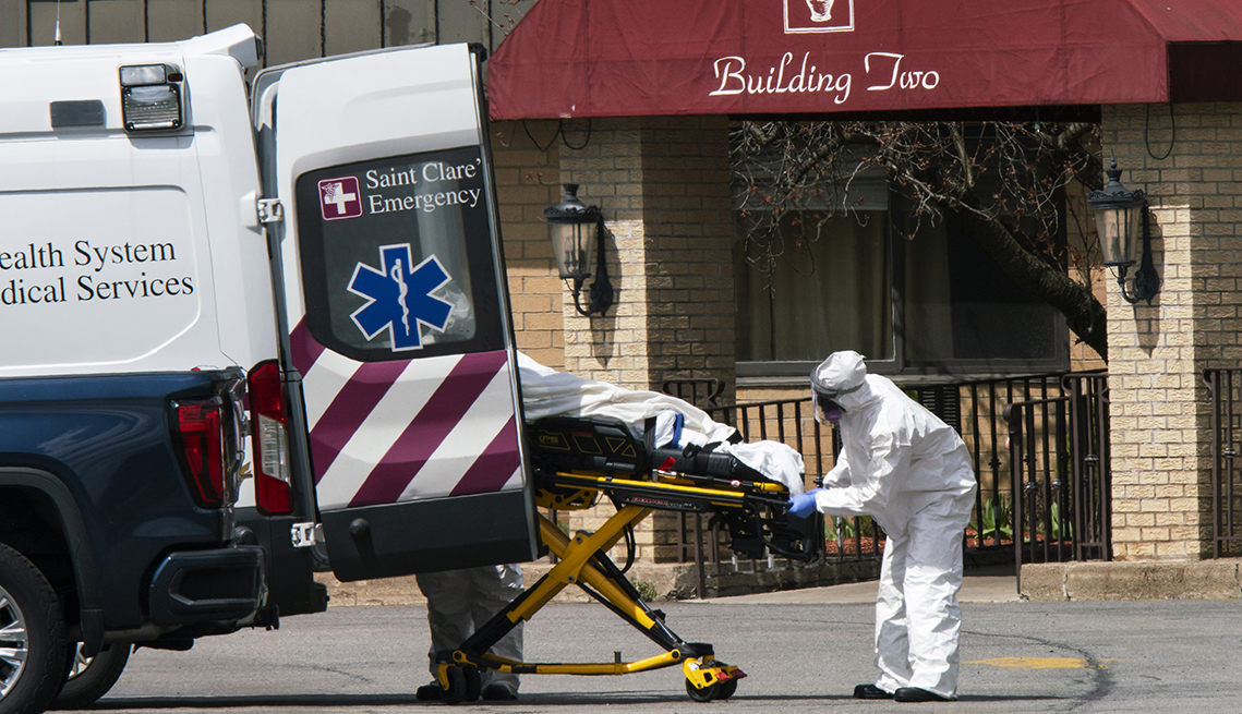 Empleados médicos suben una persona fallecida a una ambulancia