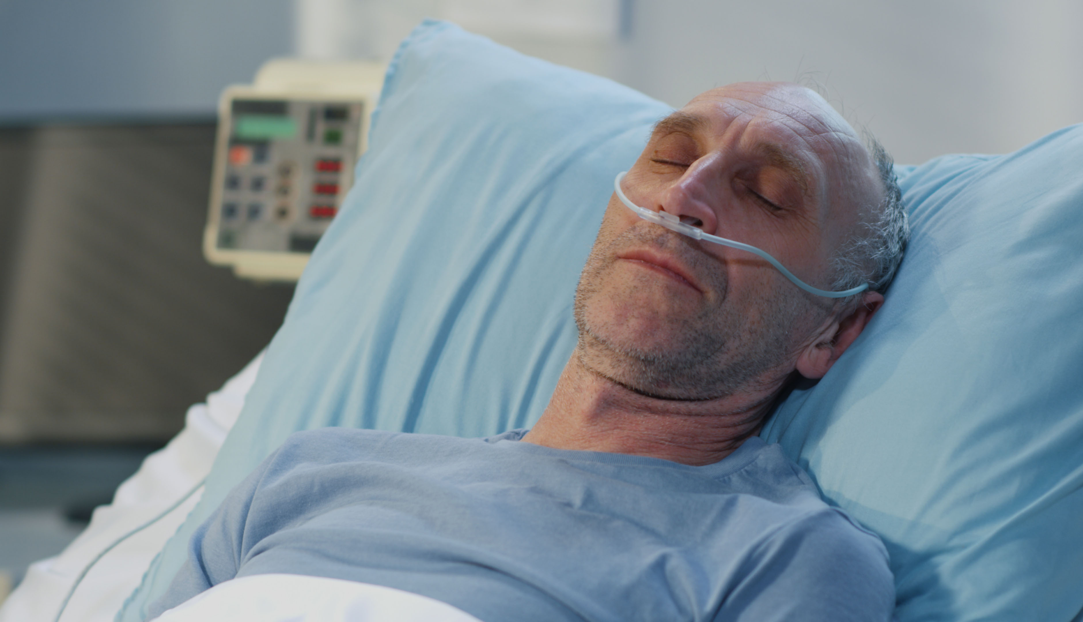 close up of male patient lying in hospital with a nasal canula in his nose to help with oxygen