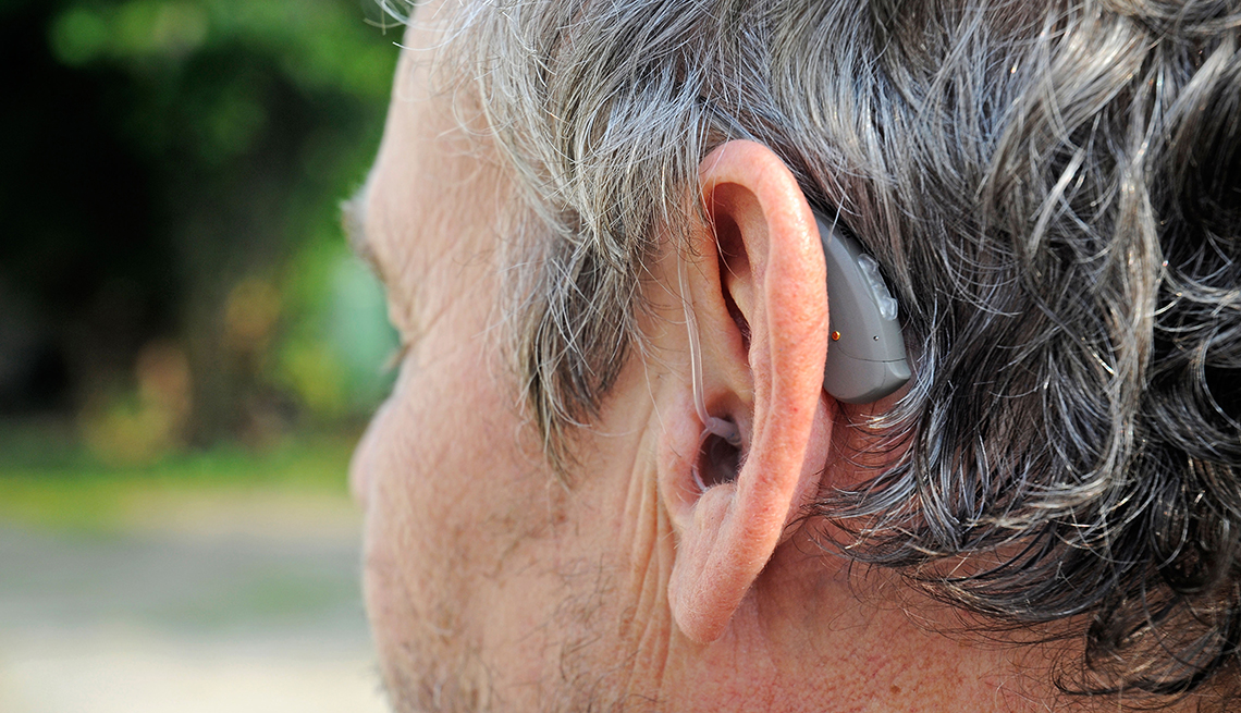 Un hombre que usa audífonos para oir mejor