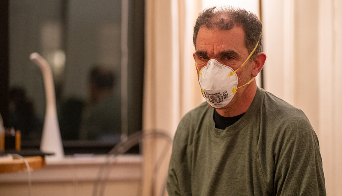 a male nurse wears a protective face mask