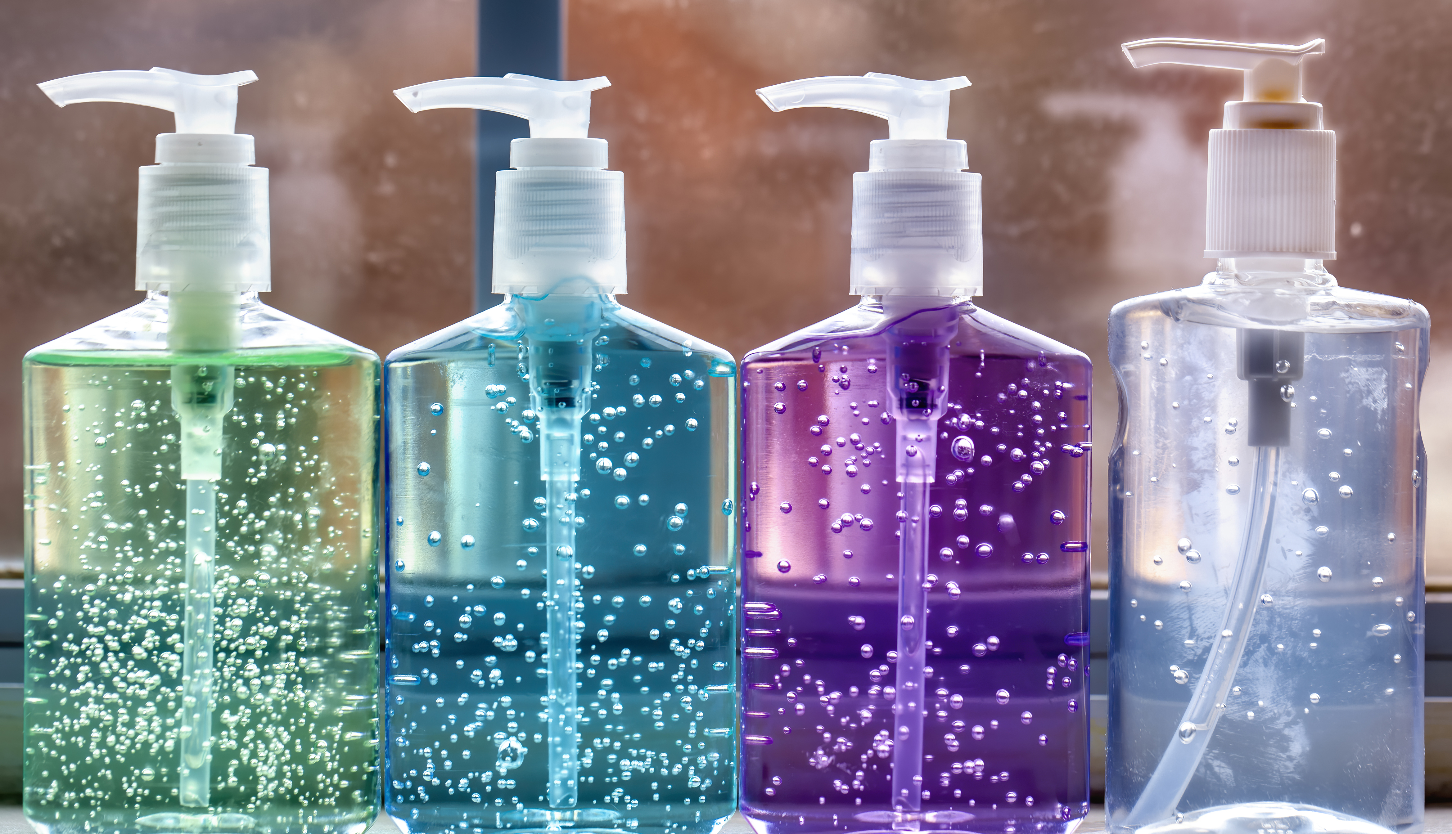 Closeup of four colorful hand sanitizer pump bottles