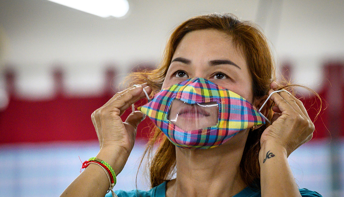 a woman uses a see-through face mask designed for deaf or hard of hearing people