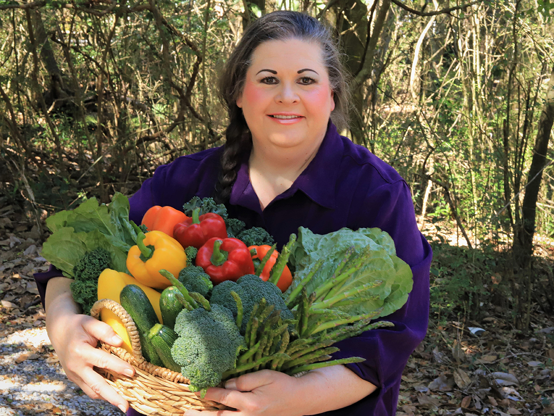Anita Lesko carga verduras en una canasta