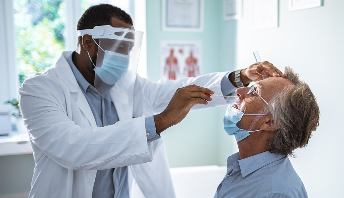 man having a nasal swab test done by a medical provider