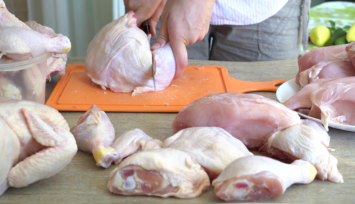 A person cutting a chicken