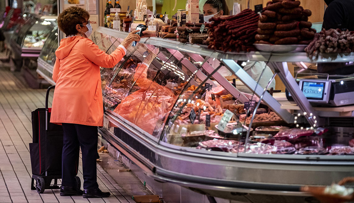 Una mujer ordena comida en el area del deli de un supermercado