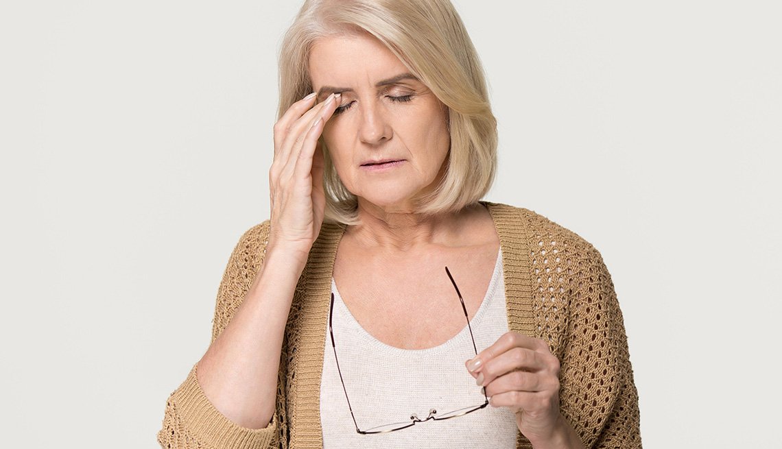 Woman touching her eyes, she looks uncomfortable.