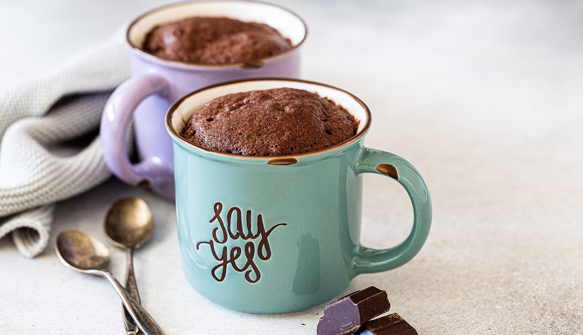 Two mugs of chocolate cake in vintage colorful cups with the word say yes.