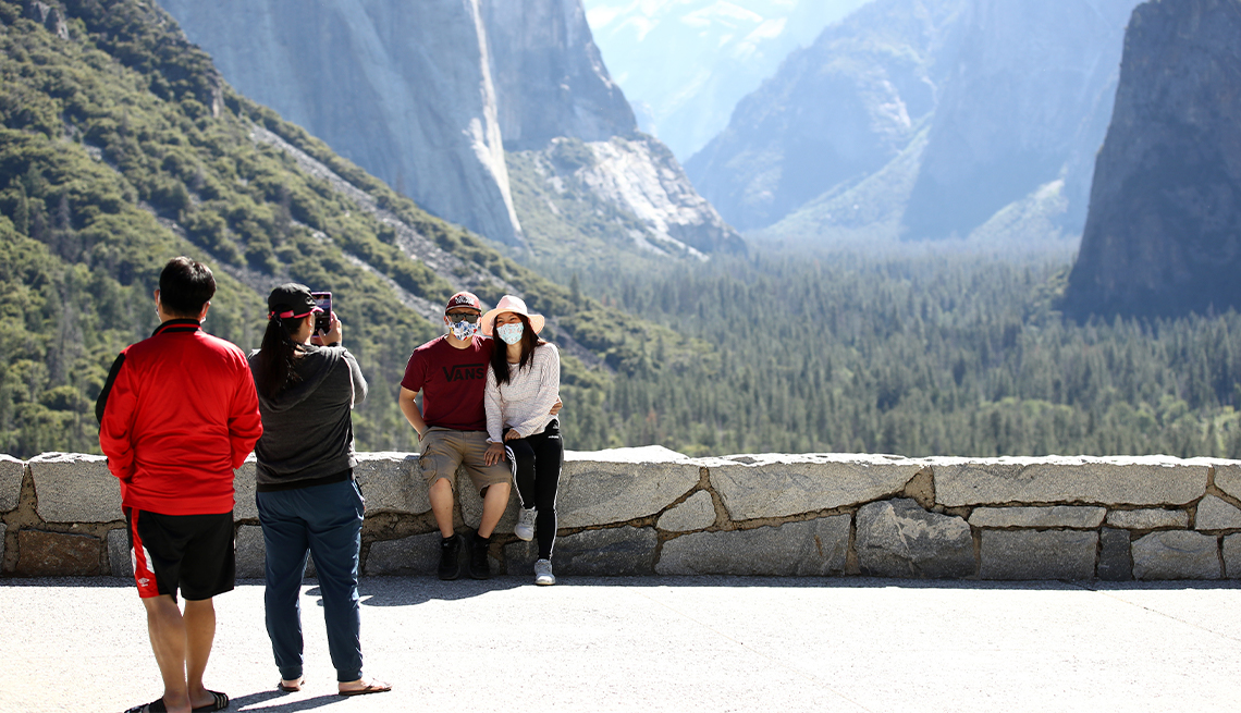 a couple poses for a photograph at a scenic overlook at yosemite national park in california
